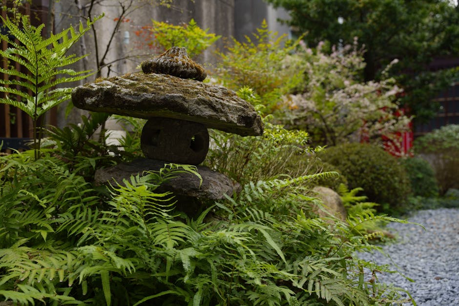 A serene Japanese garden in Taipei with a traditional stone lantern surrounded by lush greenery.